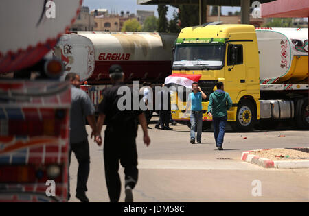 21 juin 2017 - Nusseirat, dans la bande de Gaza, territoire palestinien - Palestiniens à pied comme les camions transportant du carburant égyptien arrivent à Gaza's power plant à Nusseirat, dans le centre de la bande de Gaza après l'entrée dans le sud de la bande de Gaza de l'Egypte à travers le passage de Rafah le 21 juin 2017. L'Égypte a commencé à livrer un million de litres de carburant à Gaza, un responsable palestinien a déclaré, dans une tentative pour alléger l'enclave palestinienne désespérée de l'électricité. Le combustible, amené par camion à travers la frontière de Rafah entre l'Egypte et Gaza, seront acheminés vers la seule station d'alimentation -- fermé depuis avril en raison de Banque D'Images