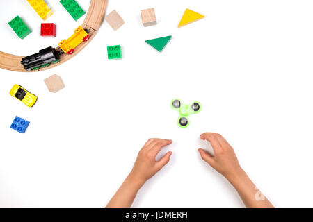 Enfants jouant avec des mains fidget spinner jouet. De nombreux jouets colorés sur fond blanc. Vue de dessus Banque D'Images