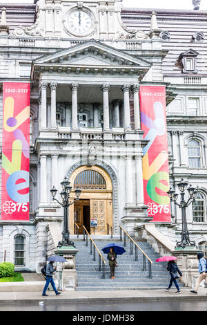 Montréal, Canada - le 26 mai 2017 : Hôtel de ville entrée dans la région du Québec avec des gens qui marchent avec des parasols sous la pluie des jours nuageux Banque D'Images