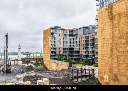 Montréal, Canada - le 26 mai 2017 : nouvel appartement moderne condos en construction avec la saleté et les camions en ville dans la région du Québec au cours d'eau de pluie nuageux Banque D'Images