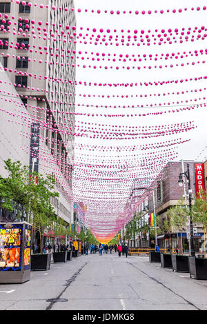 Montréal, Canada - le 26 mai 2017 : Les gens de marcher sur la rue Sainte Catherine dans le Village gai de Montréal dans la région du Québec avec des décorations suspendues Banque D'Images