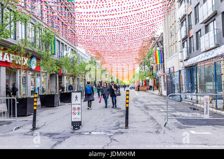 Montréal, Canada - le 26 mai 2017 : Les gens de marcher sur la rue Sainte Catherine dans le Village gai de Montréal dans la région du Québec avec des décorations suspendues Banque D'Images