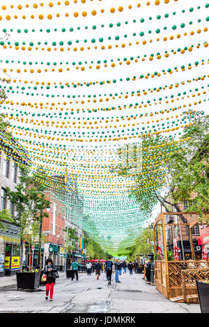 Montréal, Canada - le 26 mai 2017 : Les gens de marcher sur la rue Sainte Catherine dans le Village gai de Montréal dans la région du Québec avec des décorations suspendues Banque D'Images