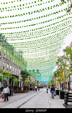 Montréal, Canada - le 26 mai 2017 : Les gens de marcher sur la rue Sainte Catherine dans le Village gai de Montréal dans la région du Québec avec des décorations suspendues Banque D'Images