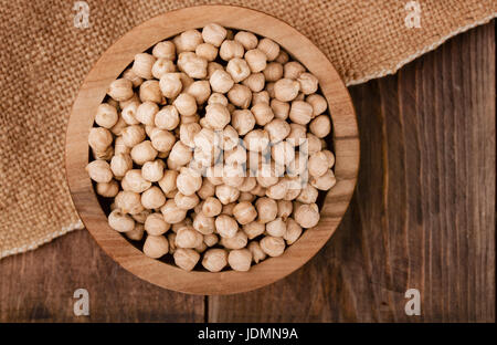 Vue de dessus du bol chickpeasl séché sur fond de bois. Banque D'Images