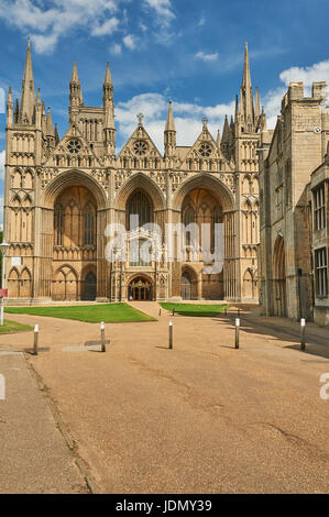 L'avant de l'ouest de la cathédrale de Peterborough baignée de soleil contre un ciel bleu. Banque D'Images