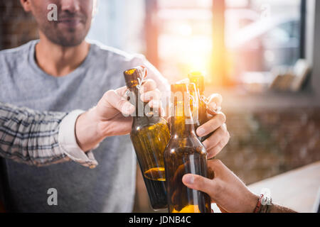 Vue rapprochée des jeunes s'amuser et de cliquetis de bouteilles de bière Banque D'Images