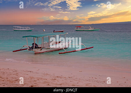 Bateau traditionnel sur la plage de l'île de Gili Meno, l'Indonésie au coucher du soleil Banque D'Images