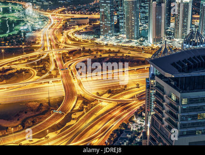 Vue aérienne de grande jonction autoroutière à Dubaï (Émirats arabes unis, dans la nuit avec les illuminations de la ville et les racloirs. Voyage coloré et le transport de fond. Banque D'Images