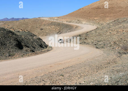 Véhicule utilitaire sport (VUS) voiture via S-se penche sur la route de gravier en Namibie, Afrique Banque D'Images