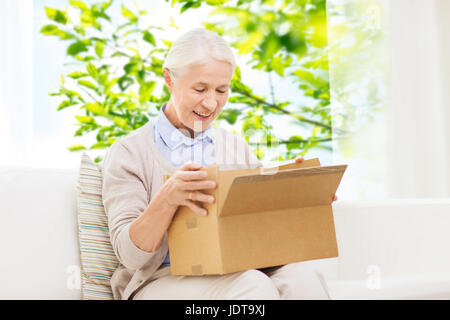 Happy senior woman with parcel box à la maison Banque D'Images