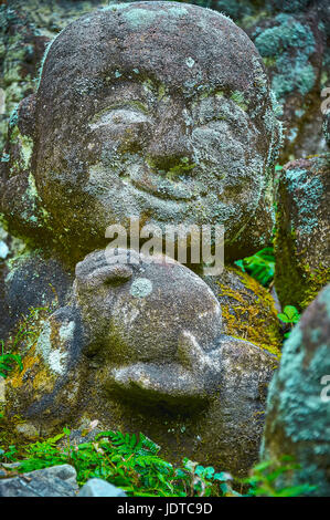 TEMPLE OTAGI, KYOTO, JAPON - 19 octobre 2016, une statue en pierre sculptée avec smiley. L'ensemble de la statue est couverts de mousse et de petites feuilles. Banque D'Images