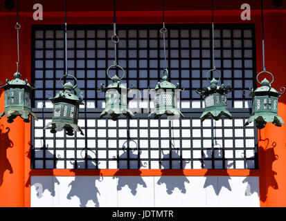 Rangées de lanternes en métal suspendus dans Kasuga Taisha Temple, Nara, Japon, jetant leur ombre sur un mur Banque D'Images