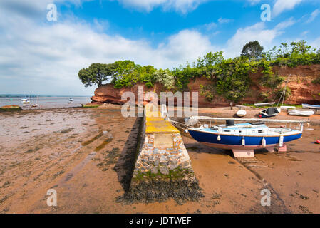 L'abri-bateau, faisant partie du port de Lympstone, Devon. La falaise de grès rouge du Trias est connu sous le nom de Darling's Rock. Banque D'Images