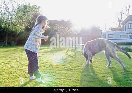 Girl blowing bubbles avec chien Banque D'Images