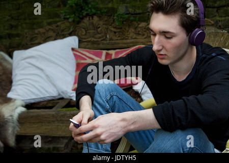 Teenage boy listening to mp3 player Banque D'Images