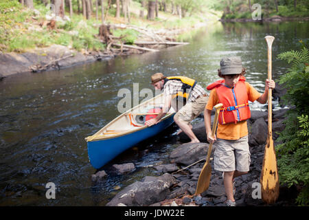 Père et fils poussant en canoe river Banque D'Images