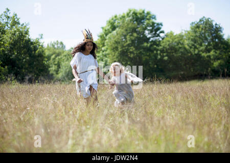 Les filles en costumes walking in field Banque D'Images