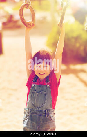 Happy little girl sur jeux pour enfants Banque D'Images