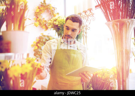 Homme avec tablette PC ordinateur au magasin de fleur Banque D'Images