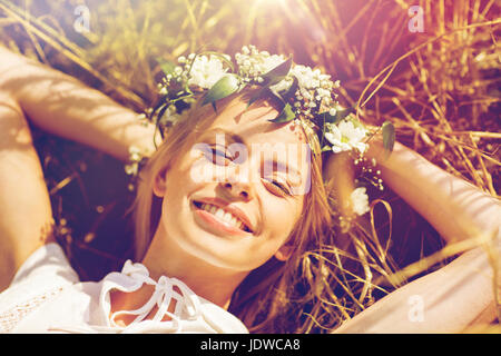 Femme heureuse dans la gerbe de fleurs couché sur la paille Banque D'Images