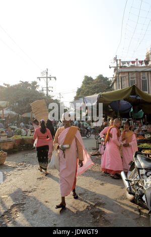 Marché Zegyo/Mandalay Myanmar - 22 janvier 2016 : des religieuses bouddhistes de différentes tranches d'âge dans leurs robes orange et rose caractéristique sont la collecte d'aumônes. Banque D'Images