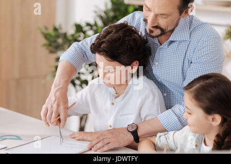 Heureux père aimant aider son fils avec les mathématiques Banque D'Images