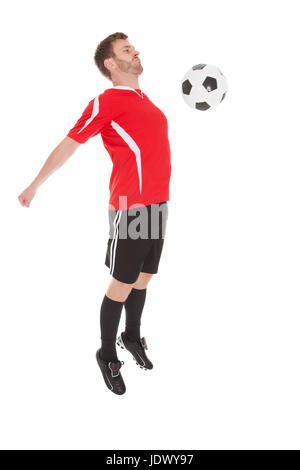 Toute la longueur du ballon de soccer player hitting avec ceinture sur fond blanc Banque D'Images