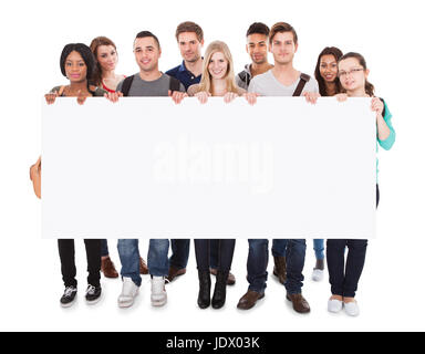 Portrait de certains étudiants du collège multiethnique afficher blank billboard against white background Banque D'Images