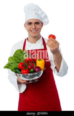 Montrant un chef de tomate dans une passoire à légumes Banque D'Images