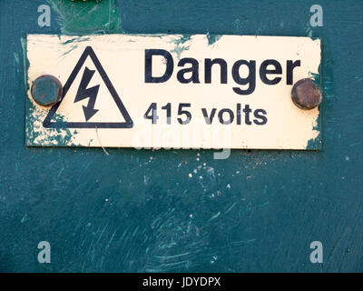 Cloué rouillé jaune signe sur la boîte de métal jaune avec flèche danger Banque D'Images