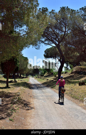 Cycliste sur la Voie Appienne (Via Appia Antica) construit par Appius Claudius Caecus à partir de 312 BC. La première longue ligne droite de la qualité des routes de Rome Banque D'Images