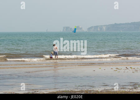 Studland Beach, péninsule de Purbeck, Dorset, UK, 21 juin 2017. Sur ce qui pourrait être le dernier jour de la vague de chaleur actuelle, c'est un autre jour par temps chaud et ensoleillé sur la belle étendue de sable de la côte sud populaire avec les vacanciers et les excursionnistes. Une brise de mer animé les températures à 24 degrés, quelques degrés de moins que le record la température enregistrée à l'intérieur des terres. Un garçon et une pataugeoire pour enfants. Old Harry Rocks dans l'arrière-plan. Banque D'Images