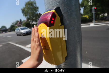 Neu-Ulm, Allemagne. 22 Juin, 2017. Tara Littel appuie sur un bouton à une intersection à Neu-Ulm, Allemagne, 22 juin 2017. La voix declarding : "Merci, c'est vert dans un instant' peut être ensuite entendu un orateur. La générale des feux de circulation sont censés réduire les risques de la circulation pour les enfants. Photo : Karl-Josef Opim/dpa/Alamy Live News Banque D'Images