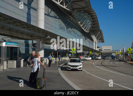 Les voyageurs arrivant à l'aéroport international de San Francisco attendent le transport terrestre, Millbrae CA Banque D'Images