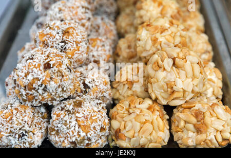 Tas de douceurs maison. Arachides et noix de coco balls libre sur l'échoppe de marché en plein air. Banque D'Images