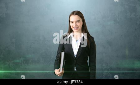 Young smiling businesswoman portrait gris avec porte-documents, fond sombre Banque D'Images