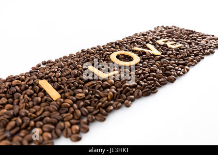 Les grains de café avec des petits gâteaux en forme de l'amour mot isolated on white Banque D'Images