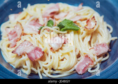 Spaghetti Carbonara avec bacon et fromage sur la plaque bleue. Banque D'Images