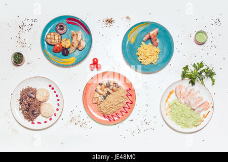 Les plaques avec des plats de viande et poisson sur un tableau blanc. Vue de dessus. Banque D'Images