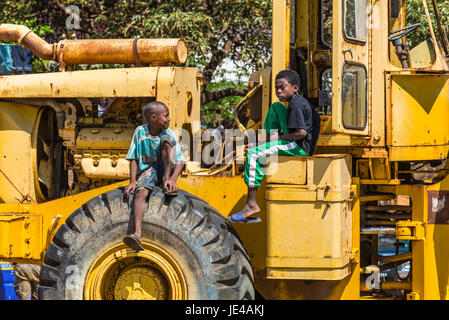 Antsiranana, Madagascar - Le 20 décembre 2015 : les garçons malgaches non identifiés s'asseoir sur le tracteur et parler à Antsiranana (Diego Suarez), Madagascar, l'Afrique. Banque D'Images