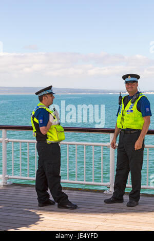 Les agents de soutien communautaire Police debout sur la jetée de Bournemouth à Bournemouth, Dorset en Juin Banque D'Images