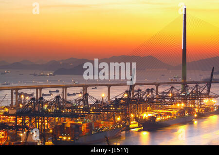 Entrepôt avec port de conteneurs et marchandises au coucher du soleil Banque D'Images