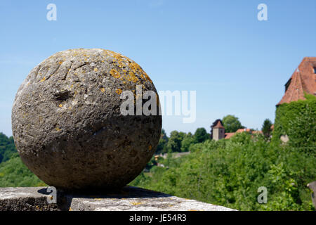 Une boule de canon en pierre comme dessus de décoration d'un grès. En arrière-plan se trouvent les remparts de Rothenburg ob der Tauber, une ville médiévale très pittoresque en Allemagne. Banque D'Images