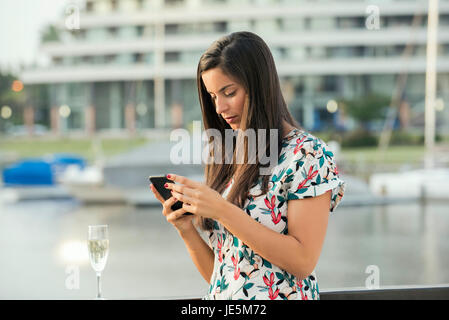 Femme à l'aide de smart phone outdoors Banque D'Images