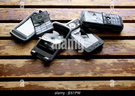 Téléphones mobiles cassés sur fond de bois Banque D'Images