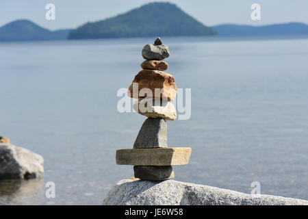 Un parfait équilibre en pierre donnant sur une vue sur l'eau. Banque D'Images