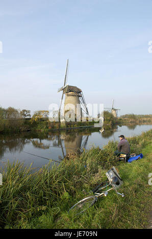 La Hollande, Pays-Bas, province de Nordholland, Kinderdijk, pêcheur dans le canal des Moulins, à l'arrière-plan Banque D'Images