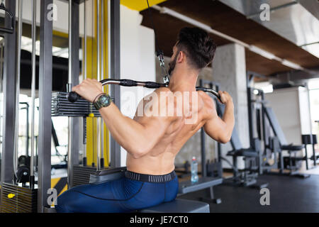 Beau jeune homme travaillant sur machine lat Banque D'Images