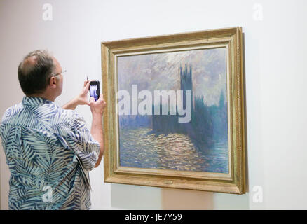 Vancouver, Canada. 22 Juin, 2017. Un visiteur prend des photos de la peinture 'Chambres du Parlement, Londres", une pièce de la "Claude Monet's Secret Garden' exposition, pendant un essai à la Vancouver Art Gallery, à Vancouver, Canada, le 22 juin, 2017. L 'Claude Monet's Secret Garden' présentera 38 tableaux qui sont considérés comme des maîtres de l'Impressionnisme Claude Monet's la plupart des collections remarquables. L'exposition est prévue pour la période du 24 juin au 1 octobre. Credit : Liang Sen/Xinhua/Alamy Live News Banque D'Images